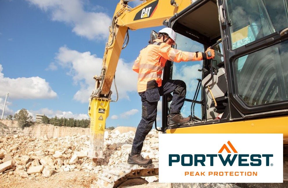 Un lavoratore con indumenti protettivi arancioni e un casco bianco sale nella cabina di un escavatore giallo in un cantiere. Sullo sfondo si può vedere un cielo azzurro e limpido e una cava. In basso a destra dell'immagine c'è il logo "Portwest Peak Protection". C'è un collegamento che porta alla nostra selezione di guanti.