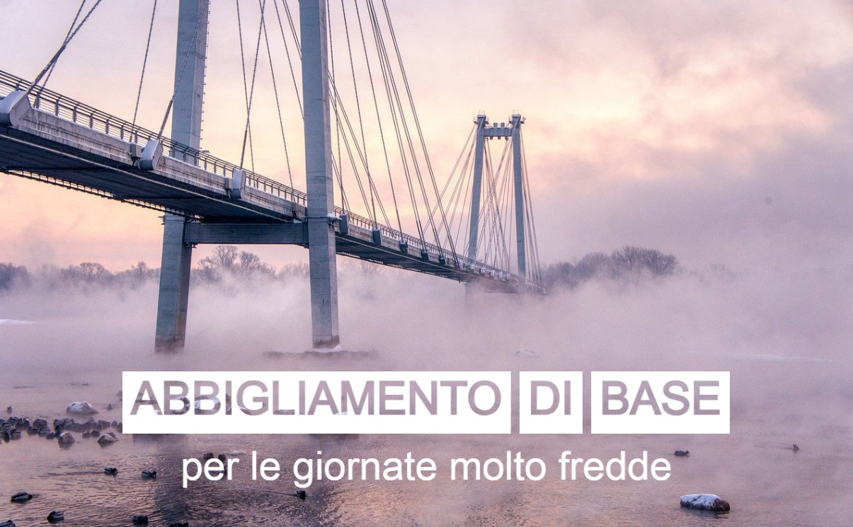 Un ponte sospeso che attraversa un fiume nebbioso e ghiacciato, catturato all'alba. Il testo "Biancheria intima per giornate lavorative molto fredde" è posizionato sopra l'immagine in grandi lettere bianche. La scena trasmette un'atmosfera invernale e gelida. Viene fornito un collegamento alla nostra biancheria intima.